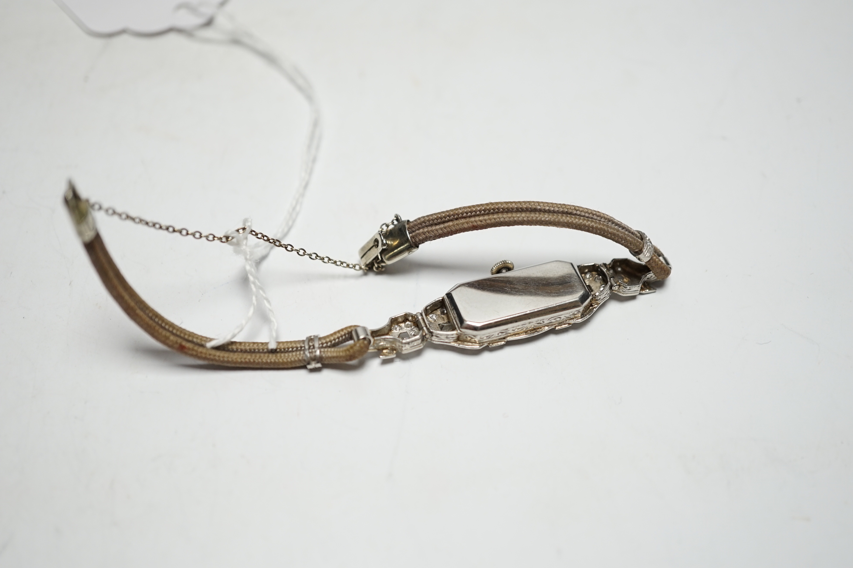 A lady's 1940's/1950's white metal (engraved platinum) and diamond cluster set manual wind cocktail watch, on a twin fabric strap.